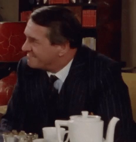 Man in Suit at Table with White Teapot