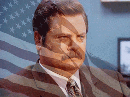 Man In Suit Behind American Flag GIF
