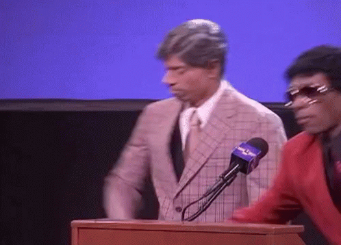 Man In Suit Behind Podium With Fox News Microphone GIF