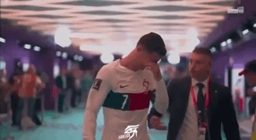 Man in Suit Beside Soccer Player in White Shirt