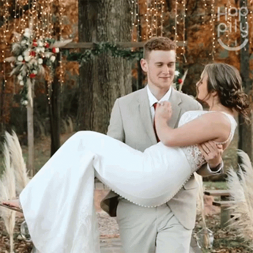 Man in Suit Carrying Woman in White Dress