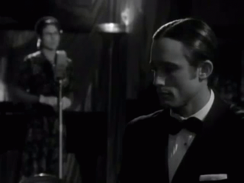 Man In Suit Clapping While Woman At Microphone Black And White GIF