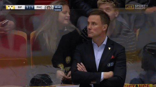 Man in Suit Covering Mouth Watching Sports