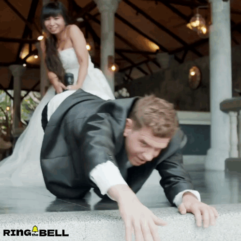 Man In Suit Crawling, Woman In Wedding Dress Standing Behind GIF