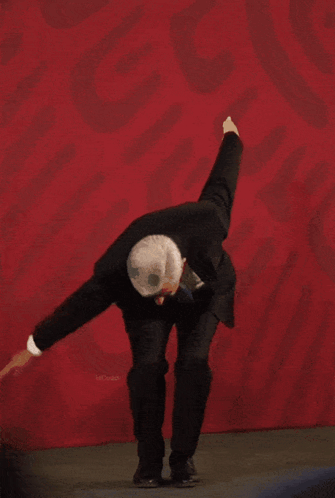 Man in Suit Dancing Before Red Wall with Mexico