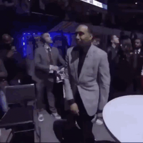 Man in Suit Dancing in Crowded Room