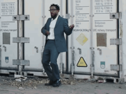 Man In Suit Dancing In Front Of UIC Railway Container GIF