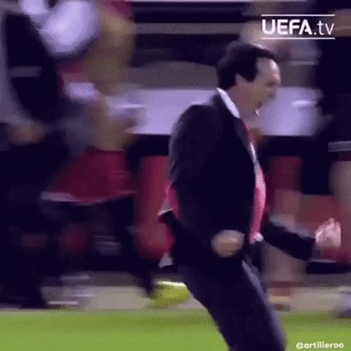 Man in Suit Dancing on Soccer Field With Crowd