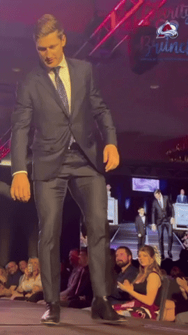 Man in Suit Dancing with Cherry Wine Sign
