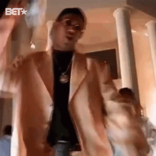 Man In Suit Dancing With Money Bag In Columned Room GIF