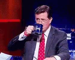 Man in Suit Drinking from Blue Mug Saying Good