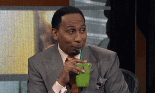 Man in Suit Drinking Green Smoothie