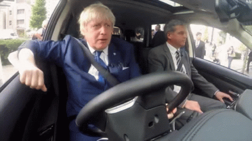 Man in Suit Driving Car With Another Man in Back