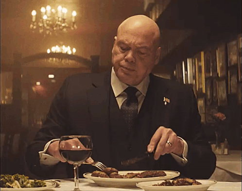 Man in Suit Eating at Table
