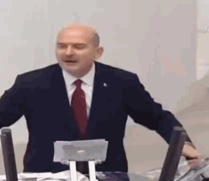 Man in Suit Giving Speech at Microphone