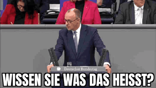 Man in Suit Giving Speech at Podium