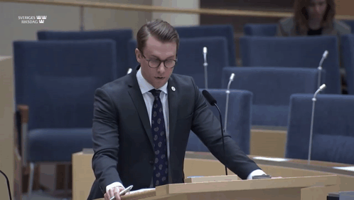 Man In Suit Giving Speech At Sveriges Riksdag Podium GIF