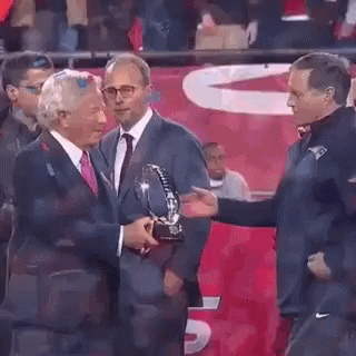 Man in Suit Giving Trophy to Another Man
