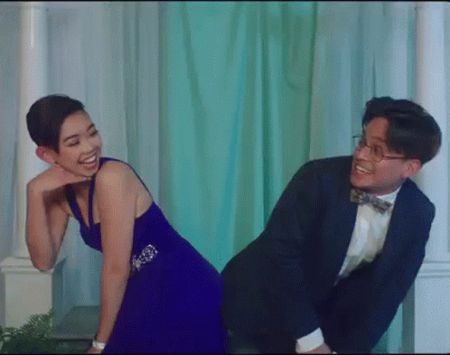Man in Suit Giving Woman in Blue Dress Piggyback Ride