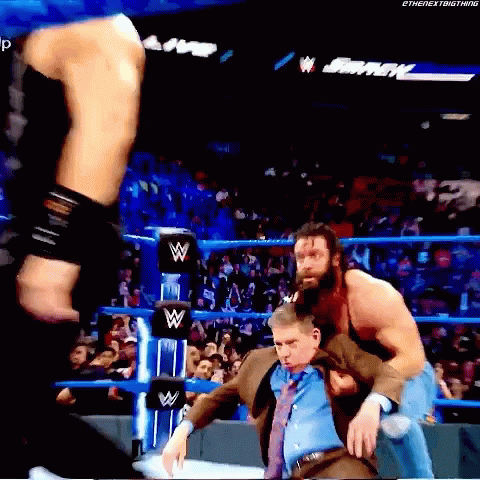 Man in Suit Held by Wrestler in Match