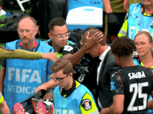 Man in Suit Helped by People in FIFA Vests