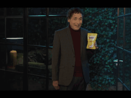 Man in Suit Holding Bag of Doritos