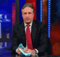 Man In Suit Holding Blue Object GIF