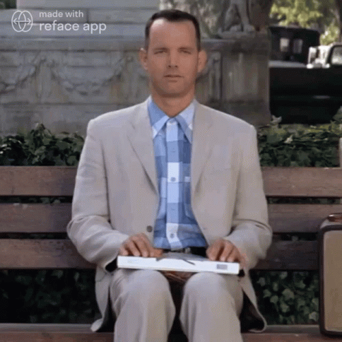 Man in Suit Holding Book on Bench