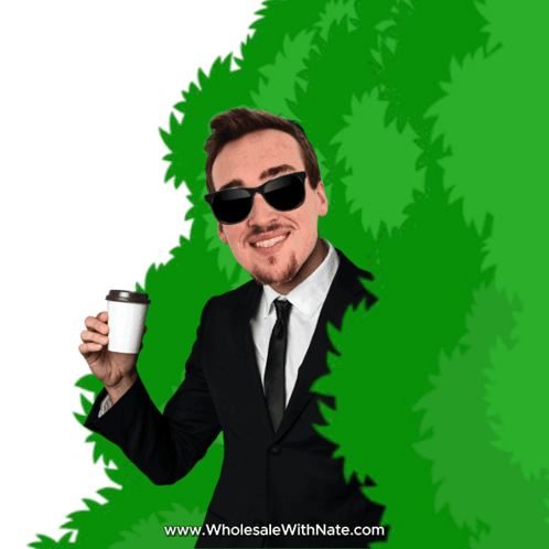 Man in Suit Holding Coffee Behind Green Bush