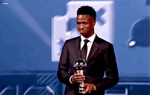Man in Suit Holding FIFA Trophy