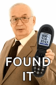 Man in Suit Holding Flip Phone Saying Found It