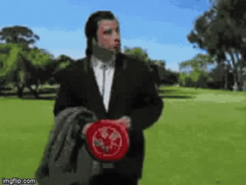 Man in Suit Holding Frisbee in Park