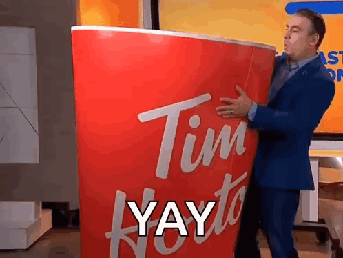 Man in Suit Holding Giant Tim Hortons Cup