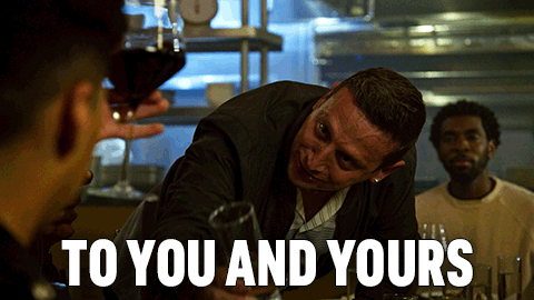 Man in Suit Holding Glass Saying To You And Yours
