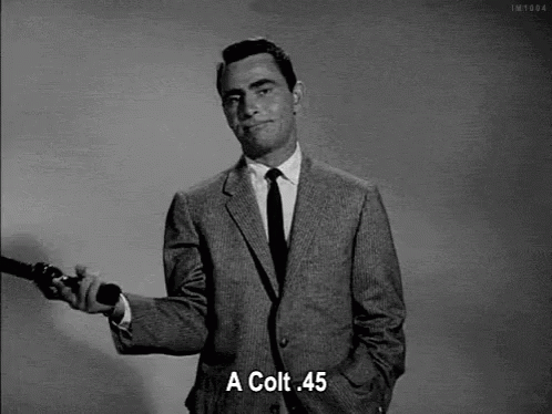Man in Suit Holding Gun and Saying Colt 45