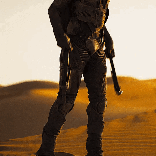 Man in Suit Holding Gun in Desert