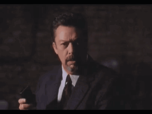 Man in Suit Holding Gun Saying Heavy Breath Again