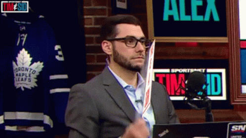 Man In Suit Holding Hockey Stick Sportsnet Sign GIF