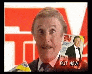 Man In Suit Holding Magazine In Front Of Face GIF