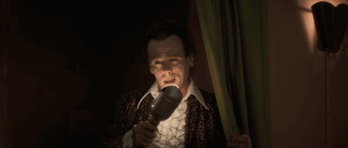 Man in Suit Holding Microphone