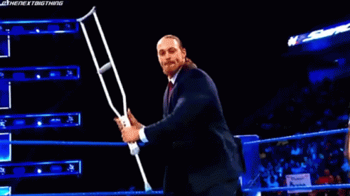 Man In Suit Holding Microphone In Wrestling Ring GIF