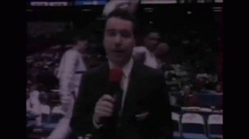 Man in Suit Holding Microphone with Bandage