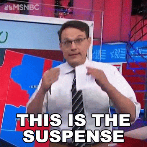 Man in Suit Holding Paper Saying This Is The Suspense
