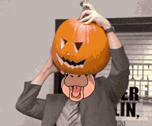Man in Suit Holding Pumpkin on Head