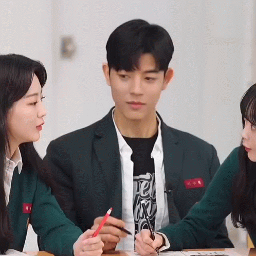 Man in Suit Holding Red Pencil With Two Girls