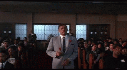 Man In Suit Holding Rose In Front Of Crowd GIF