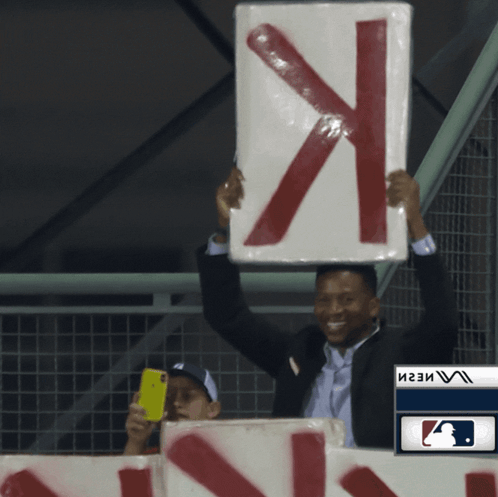 Man in Suit Holding Sign X