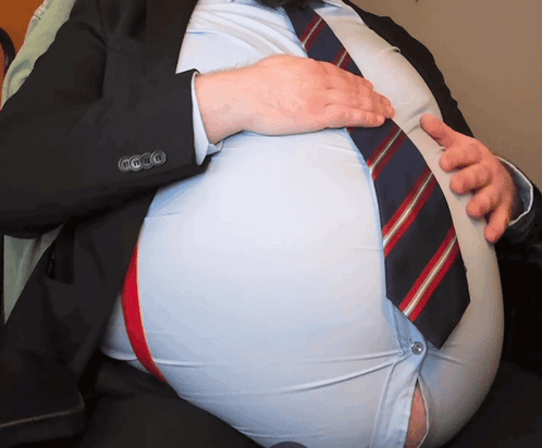 Man in Suit Holding Stomach