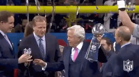 Man in Suit Holding Trophy Next to Another Man