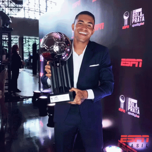 Man in Suit Holding Trophy
